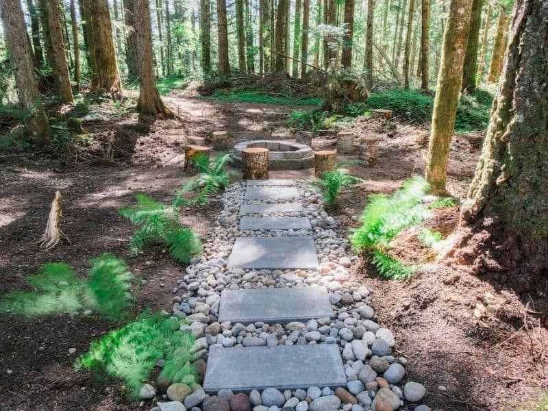 Stone pathway leading to fire pit in the woods