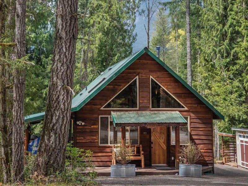 Wooden cabin with green roof and covered entryway near Mount Rainier - part of a guide to the best Mt. Rainier Cabins