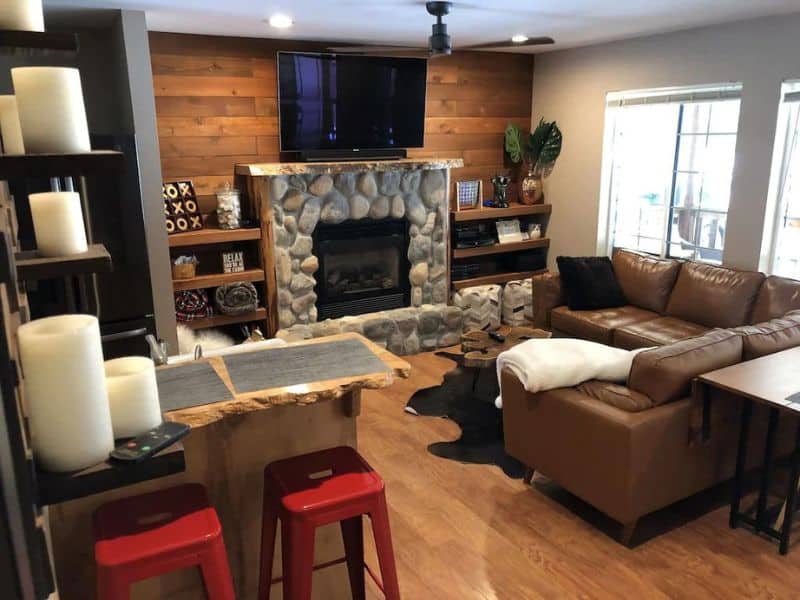 Living area in small cabin near Mt Rainier with stone fireplace and leather couches