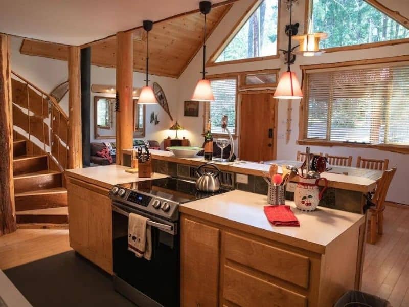 Open plan kitchen with large island overlooking living area in cabin rental near Mount Rainier