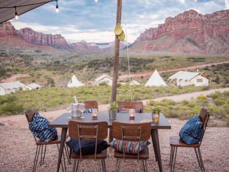 Communal dining area at Under Canvas Zion with red rock views in the distance