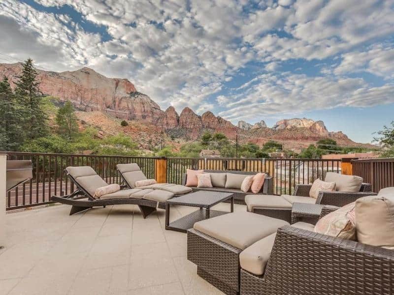 Outdoor sitting area with loungers at Watchman Villas with Zion red rocks in the background