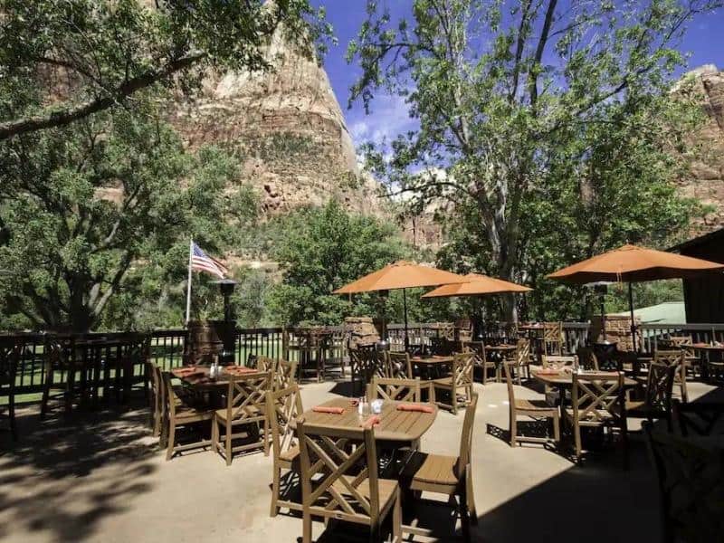 Restaurant tables on outdoor patio with red rock views at Zion National Park Lodge