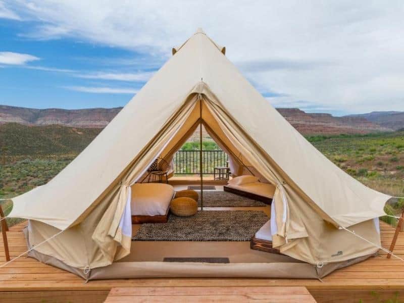 Canvas tent with luxury bedding on a wooden deck - Zion Wildflower glamping - lodging near Zion