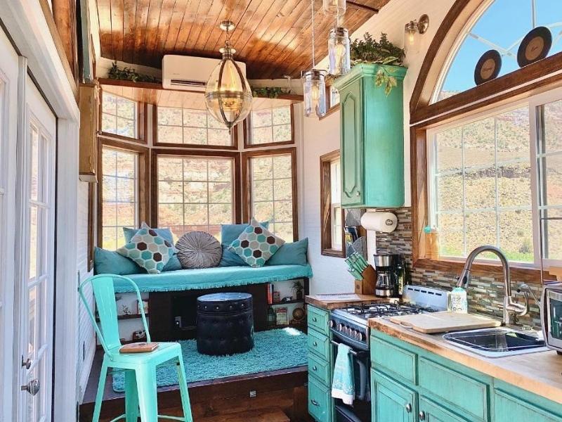 Interior of tiny house at Zions Tiny Oasis with small kitchen and nook with turquoise pain and finishes