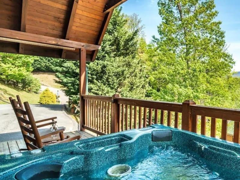 Cabin rental in Pigeon Forge with wooden deck with rocking chair and hot tub
