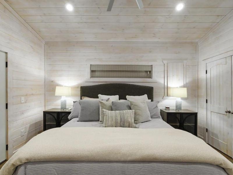 Cozy bedroom setting with a king-size bed, soft lighting, and natural wood finishes.