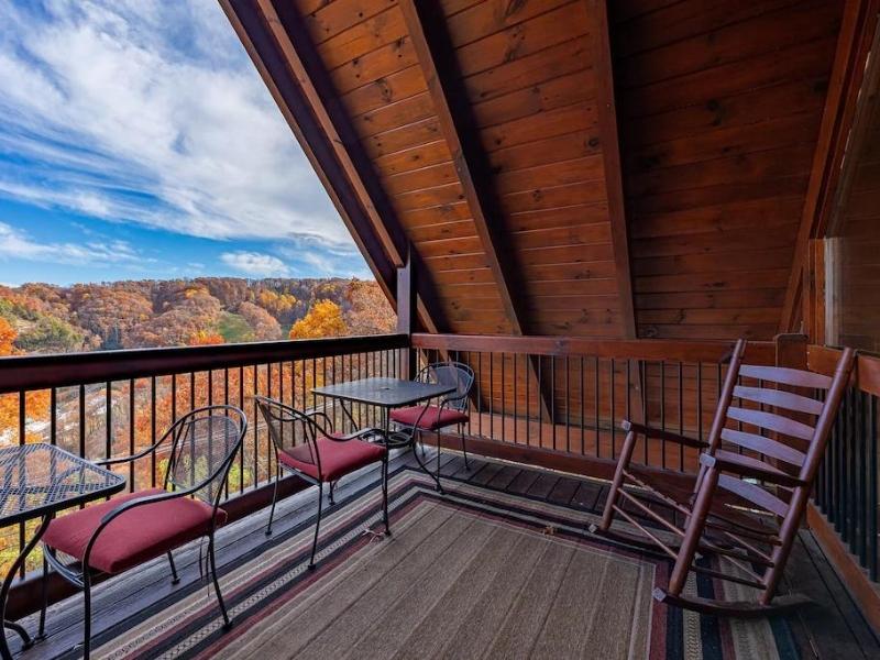 A-frame deck with tables and rocking chair overlooking the Great Smoky Mountain at cabin rental in Pigeon Forge TN