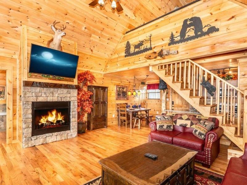 Living area with leather couches and fireplace in Pigeon Forge cabin rental