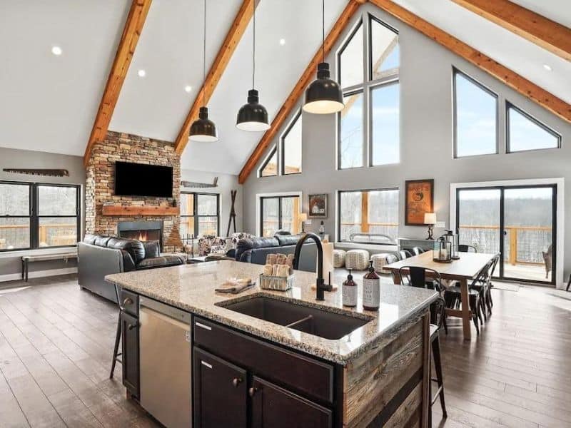 Upscale kitchen, living, and dining area with large windows in Luxury cabin in Hocking Hills sleeping up to 12