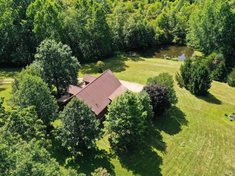 Aerial view of luxury Hocking Hills cabin rentals with a large lawn and a pond