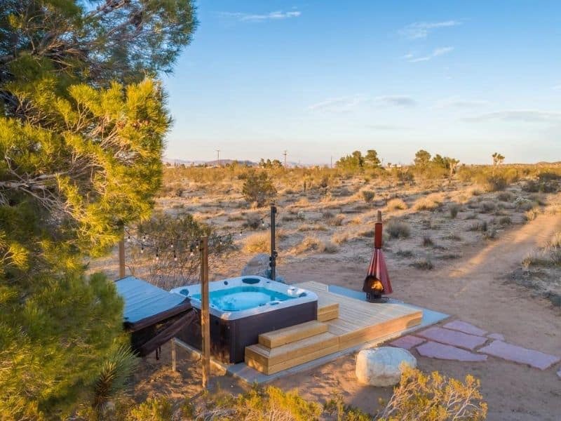 Hot tub and outdoor fireplace at Flamingo Social Club Joshua Tree Airbnb