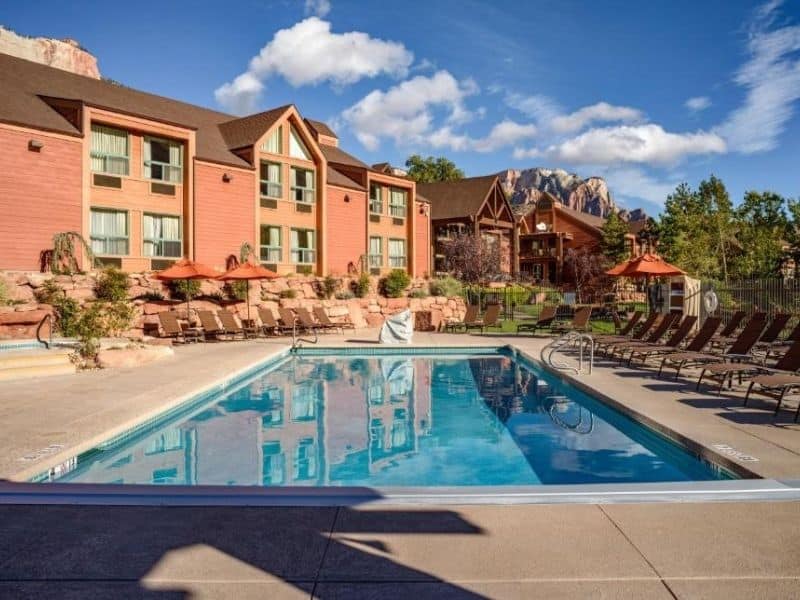 Exterior of Holiday Inn Express Springdale with pool and sun loungers - Zion National Park lodging