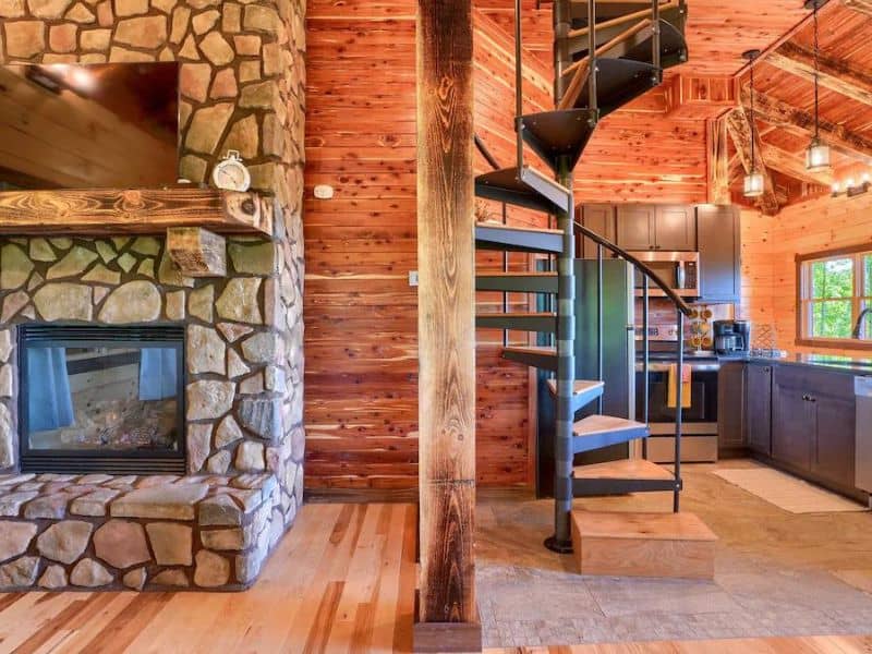 Fireplace and kitchen at treehouse vrbo near Hocking Hills, OH