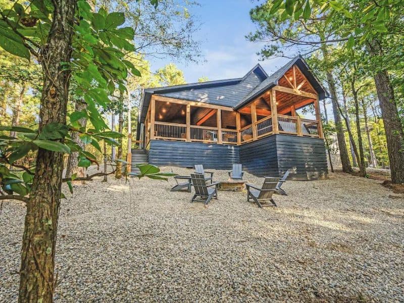 Exterior of modern wood 5 bedroom cabin in Broken Bow with outdoor seating and fire pit