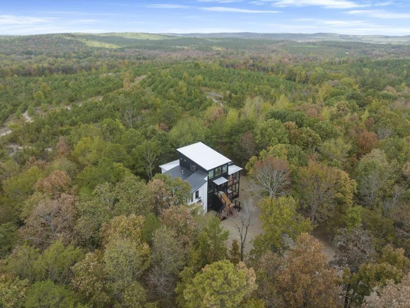 Ariel view of luxury 5 bedroom cabin in Broken Bow surrounded by forest.