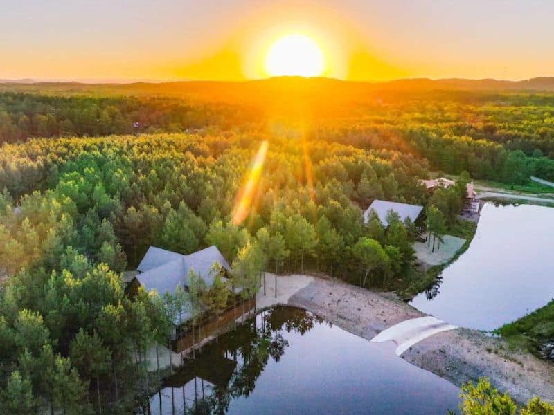 Upscale 5 bedroom Broken Bow cabin on a pond surrounding by forest at sunset