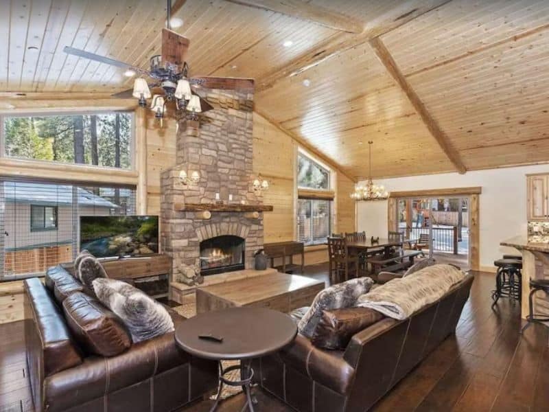 Large indoor living area with wood burning fireplace and high ceilings in Big Bear, CA