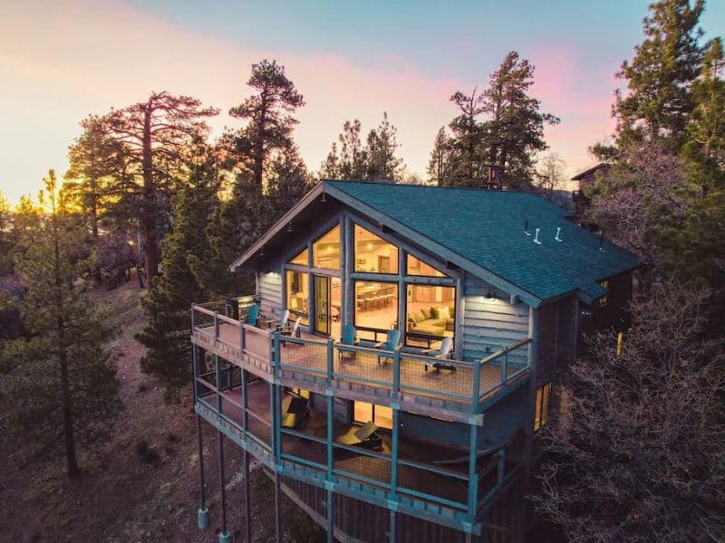 Exterior sunset view of large two-story Big Bear cabin with large decks with seating