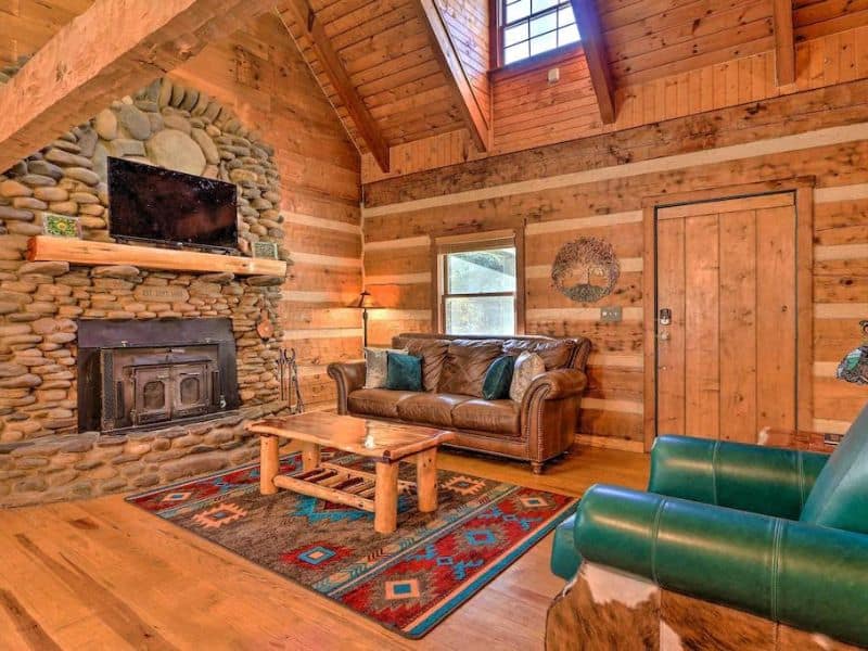 Rustic upscale cabin in Hocking Hills with stone fireplace and leather couches