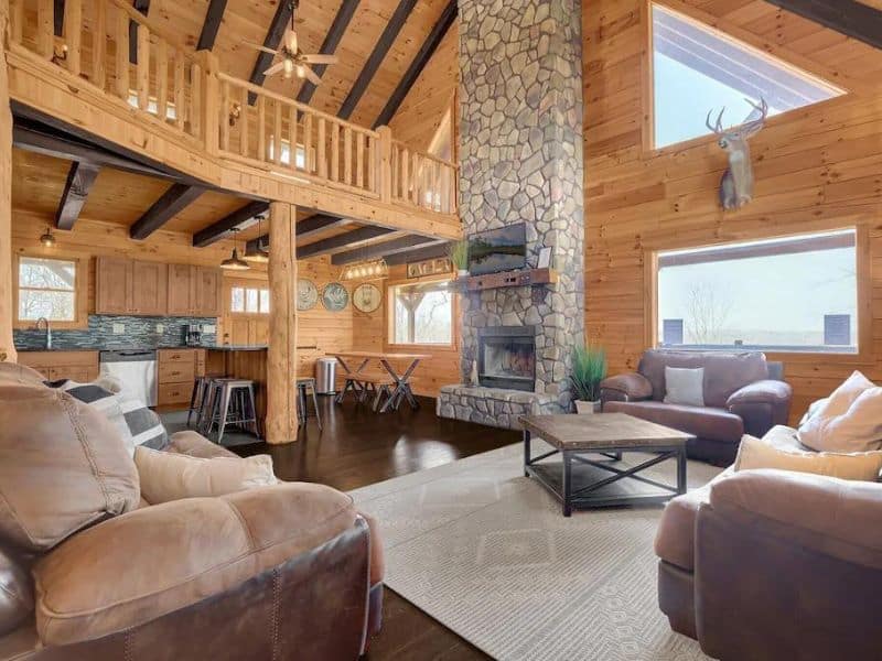 Large open living area in Hocking Hills cabin rental with huge stone fireplace and vaulted ceilings 
