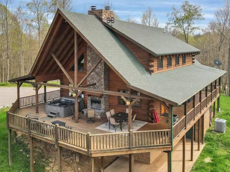 Exterior of wood cabin in Hocking Hills with outdoor fireplace and hot tub