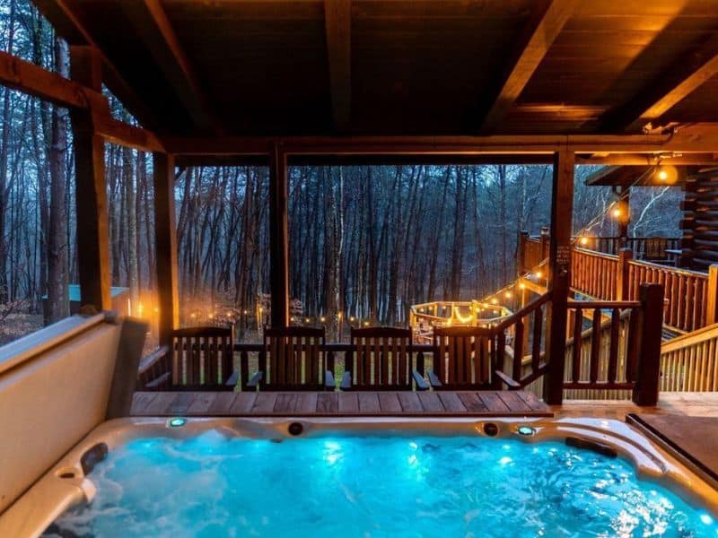 Hot tub with LED lights lit up at dusk on a deck with fairy lights