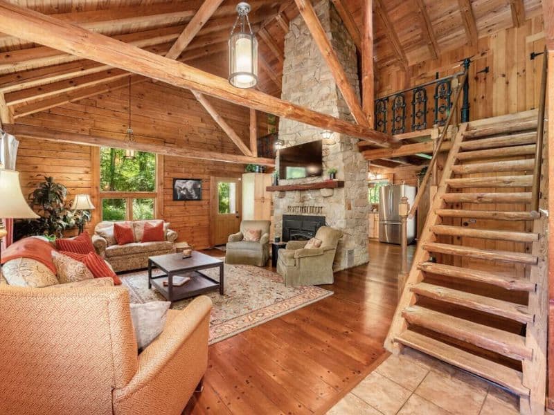 Large open plan living area with floor to ceiling stone fireplace in Hocking Hills cabin rental