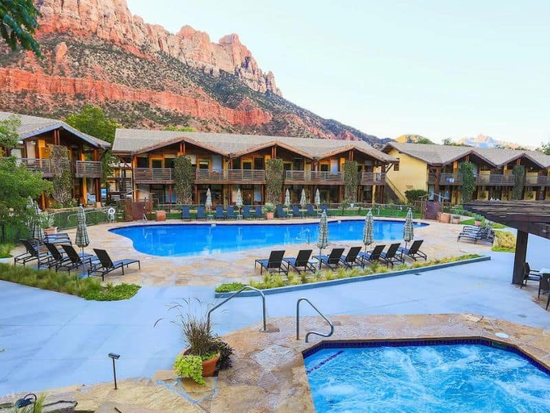 Exterior of Desert Pearl Inn in Springdale UT with large pool and Zion red rocks in the background - best Zion lodging options