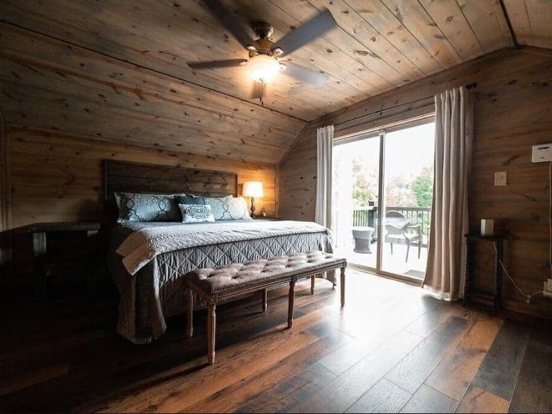 King bedroom with leather bed footrest and wood accents