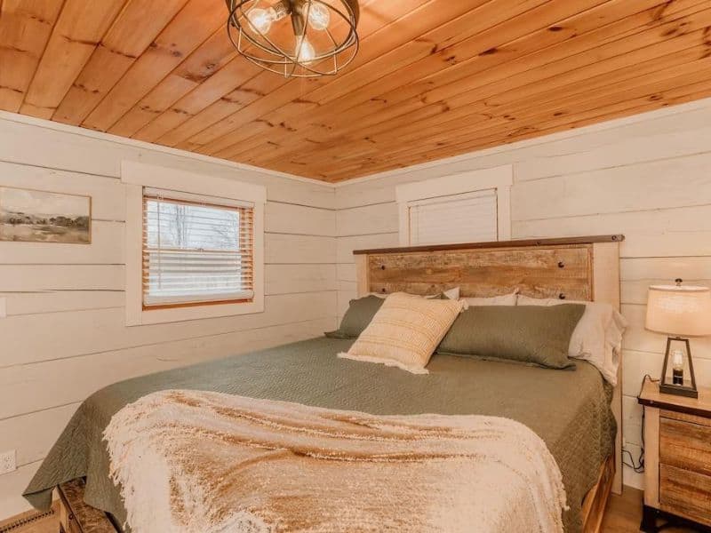 Bedroom of Pigeon Forge vacation home, with clean modern detailing, light colors and wooden accents.