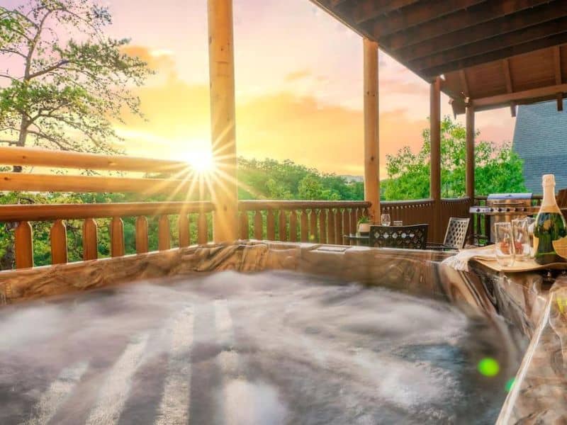 View from the Jacuzzi of Pigeon Forge cabin, which sits on a log built porch looking out to a view of the forest.