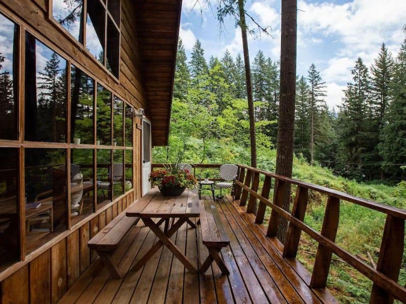 Wood cabin with deck and picnic table surrounded by forest near Mount Rainier National Park