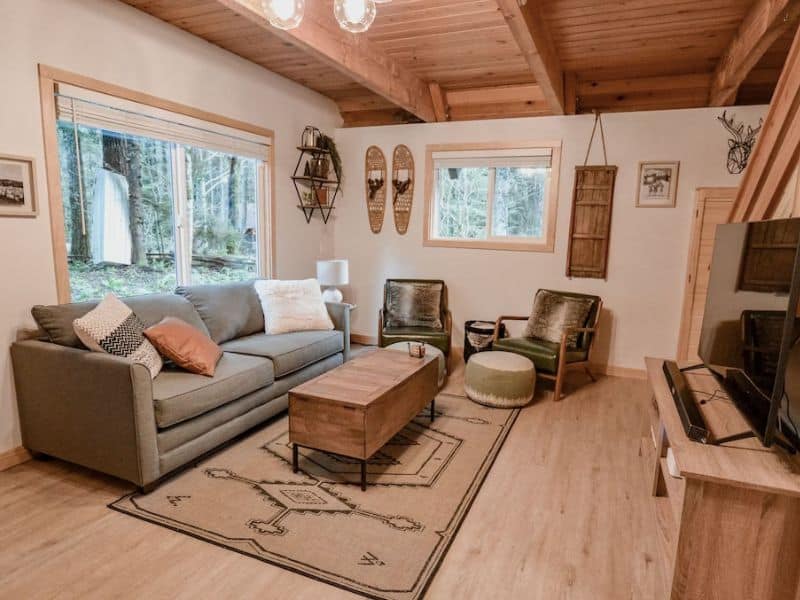 Cozy living area in cabin near Mt Rainier, WA with snow shoes hung on the wall as decor - part of a guide to the best Mt. Rainier cabin rentals
