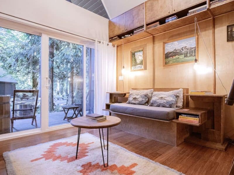 Cozy rustic cabin interior with small couch, coffee table, and area rug