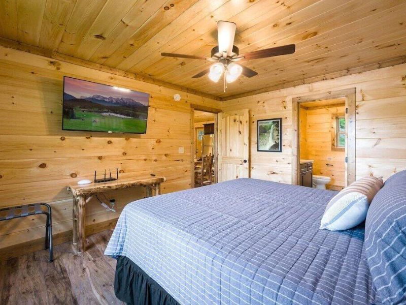 Spacious bedroom with wood finishes and ceiling fan in Gatlinburg cabin