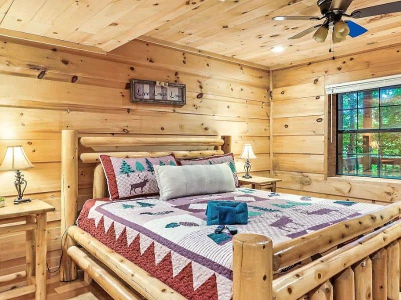 Cozy bedroom in wood cabin with quilted bed
