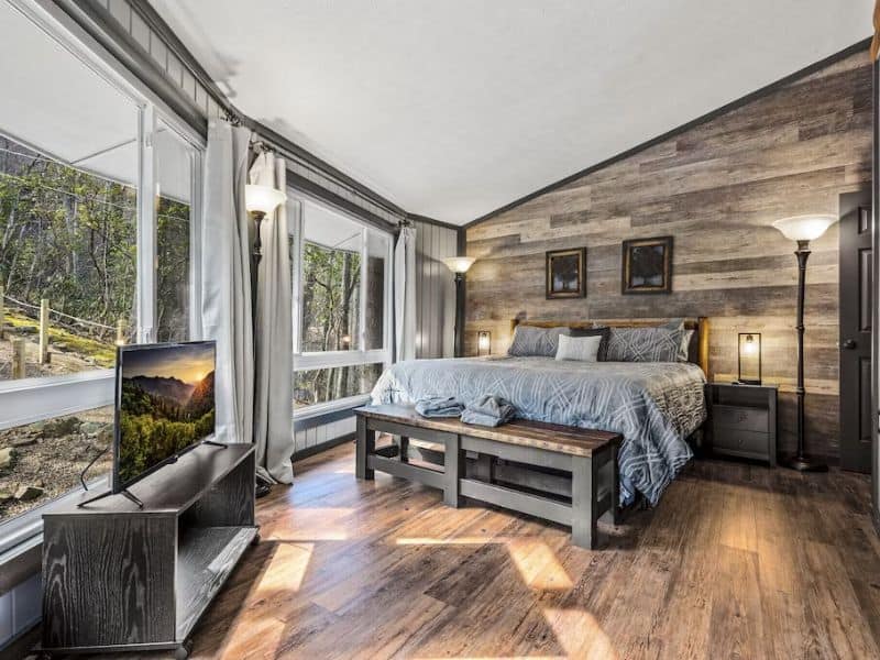 Modern rustic master suite in Gatlinburg cabin rental with king size bed and plenty of windows