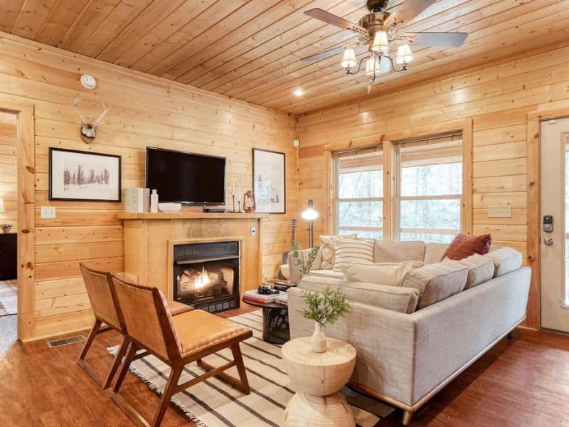 Upscale living room in Gatlinburg cabin rental with fireplace, area rug, and ample seating