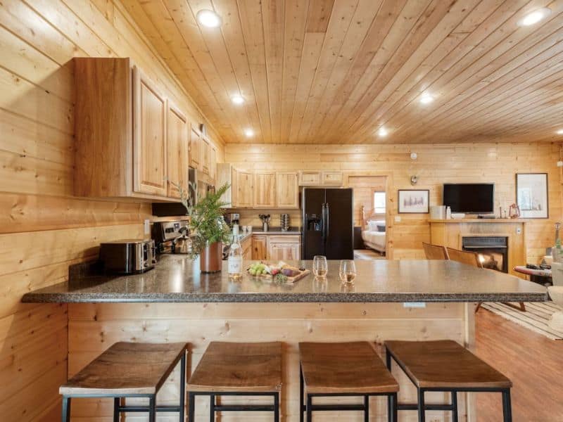 Large kitchen with wood finishes and breakfast bar counter with barstool seating