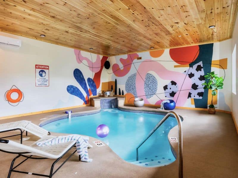 Indoor pool with colorful accent wall in Gatlinburg pet-friendly vacation rental