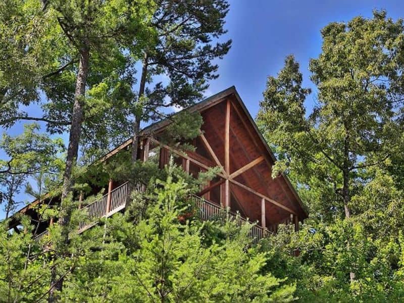 Exterior of a wood cabin surrounded by trees in Gatlinburg