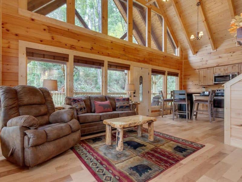 Large living room area with wood finishes, vaulted ceilings and large windows