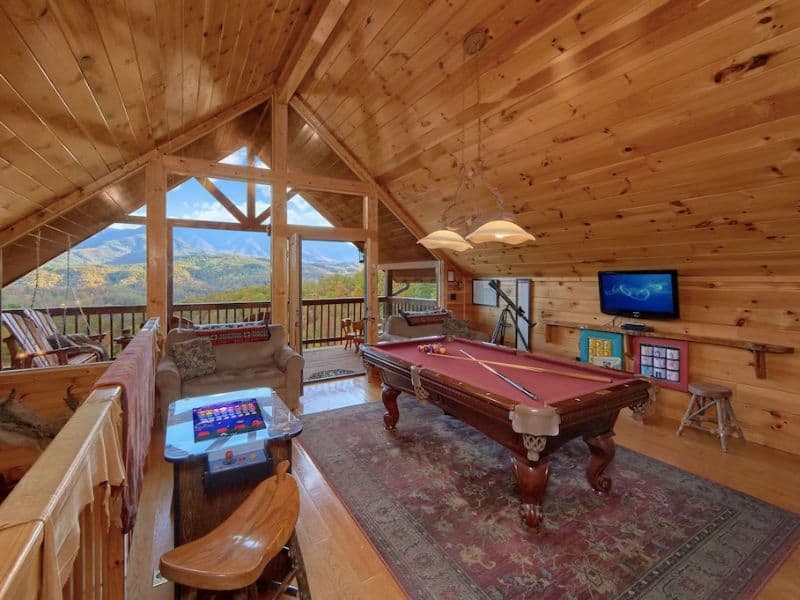 Game room in Gatlinburg cabin rental with pool table, TV, and arcade