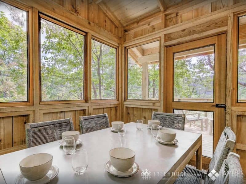 Dining area in screened in porch at Treehouse lodging at Treehouse Grove in Gatlinburg