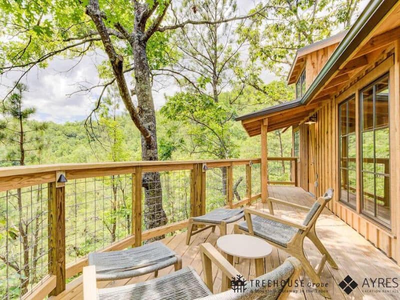 Elevated deck with seating overlooking wooded area at Treehouse Grove - pet-friendly lodging near Gatlinburg