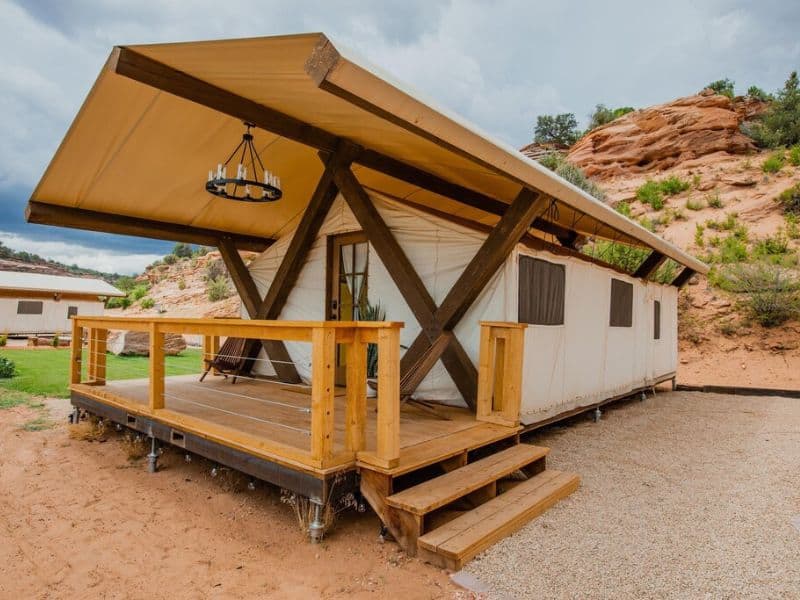Large canvas glamping tent with front porch and hanging chandelier at Cave Lakes Canyon Ranch in Kanab UT
