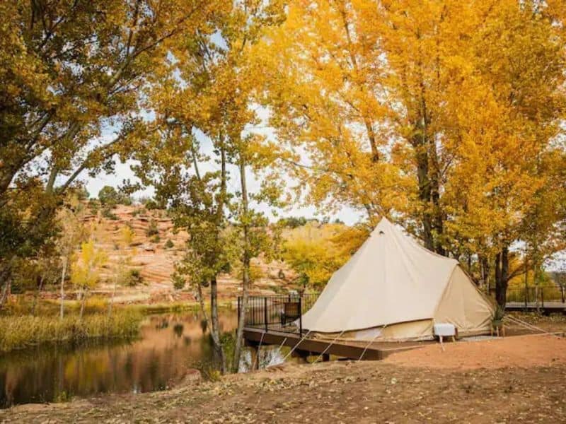 Glamping tent on wooden deck overlooking lake at Cave Lakes Canyon Ranch in Kanab near Zion National Park