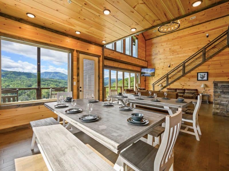 Large open dining and living area in Gatlinburg cabin rental with windows overlooking the Great Smoky Mountains