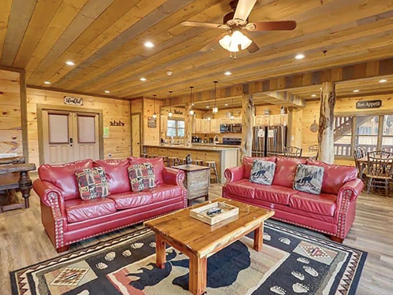 Open living area with red leather couches and coffee table in vacation rental in Gatlinburg